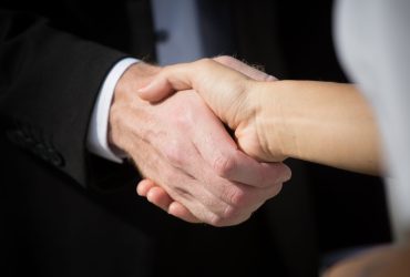 Business handshake and business people. Business handshake for closing the deal after singing the lucrative contract between companies.